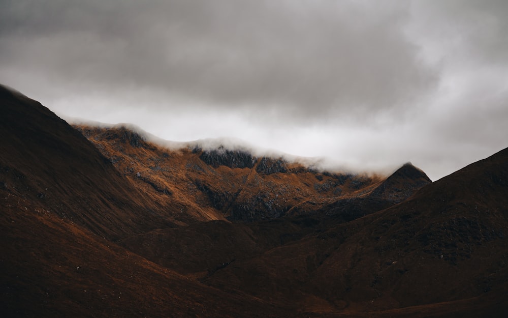 a mountain range under a cloudy sky