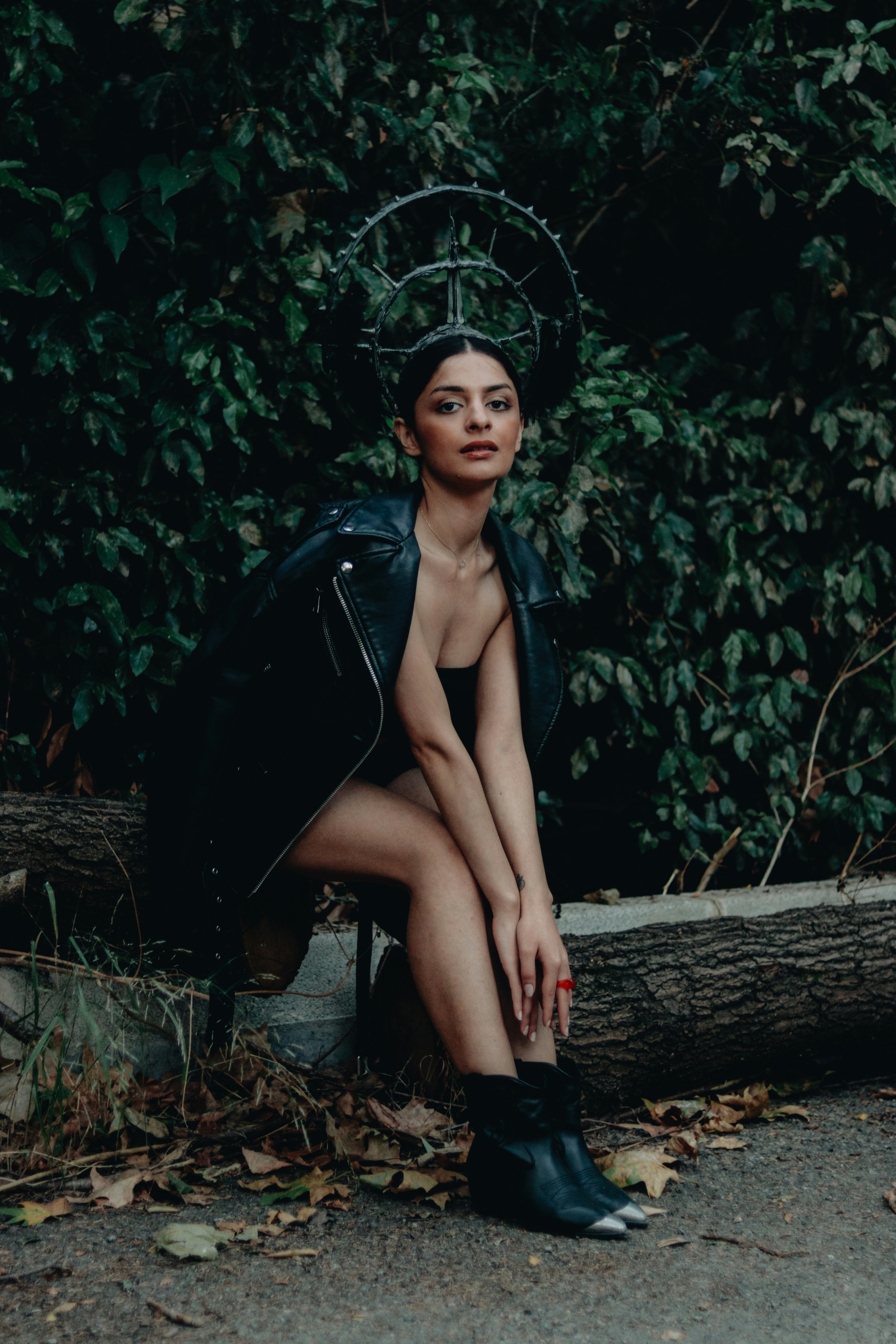 une femme assise sur un banc devant un arbre