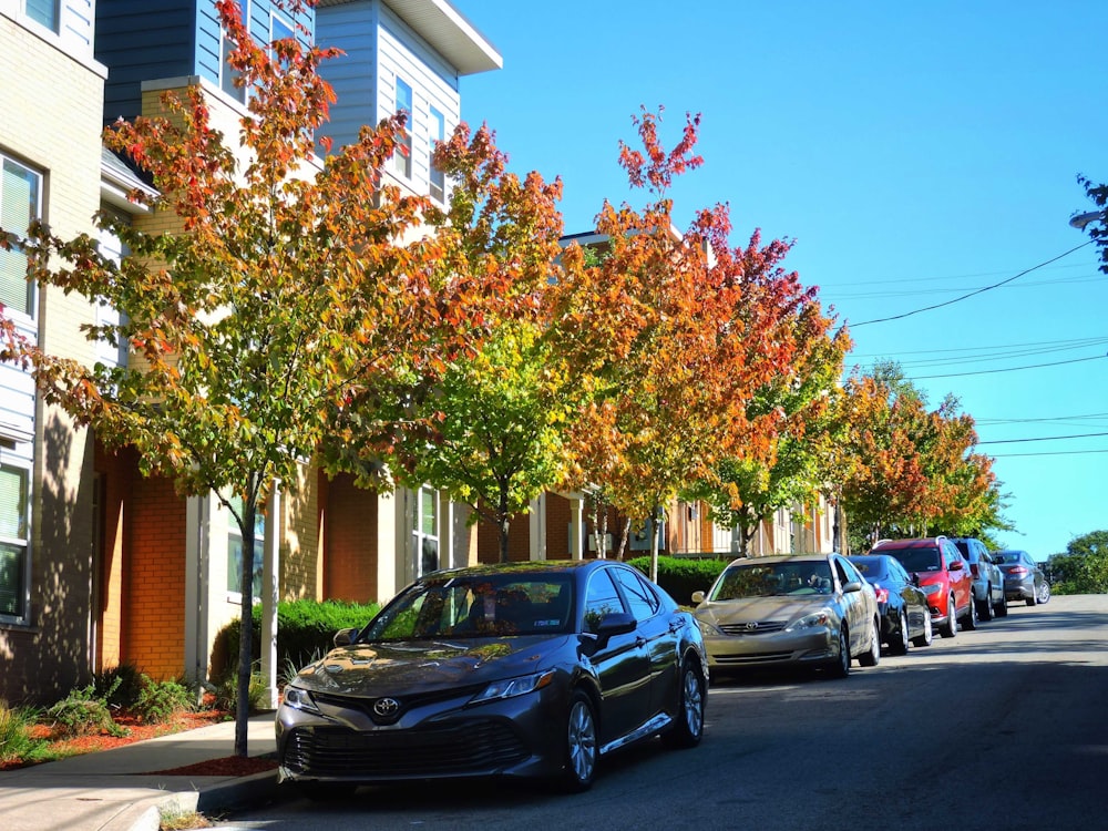 a row of parked cars sitting on the side of a road