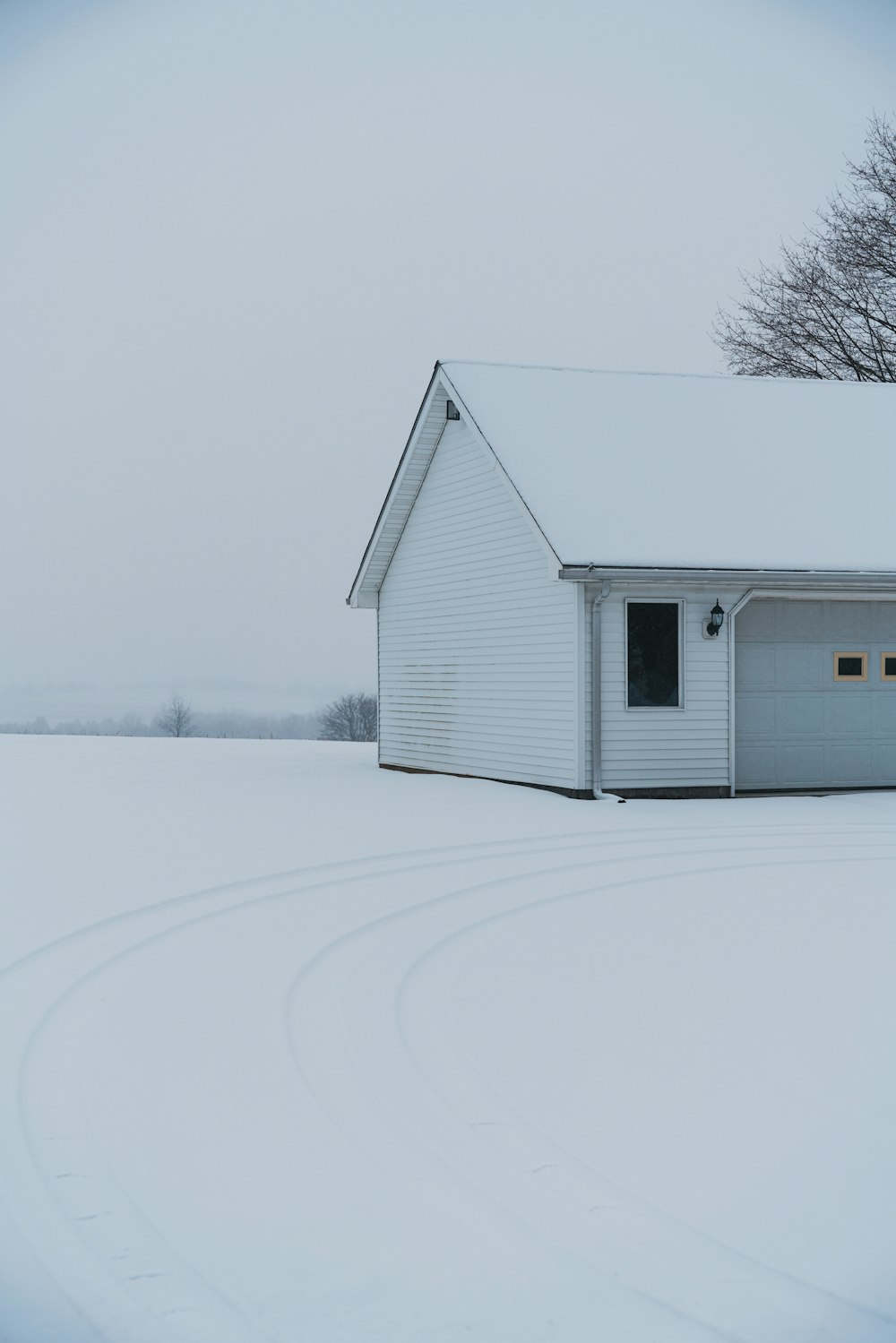a white house in the middle of a snowy field