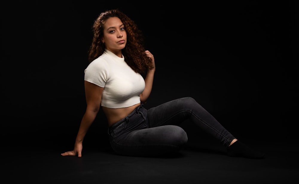 a woman is sitting on the floor posing for a picture