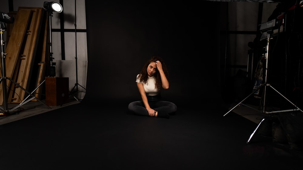 a woman sitting on the floor in front of a camera