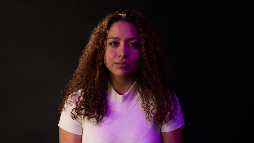 a woman with curly hair is posing for a picture