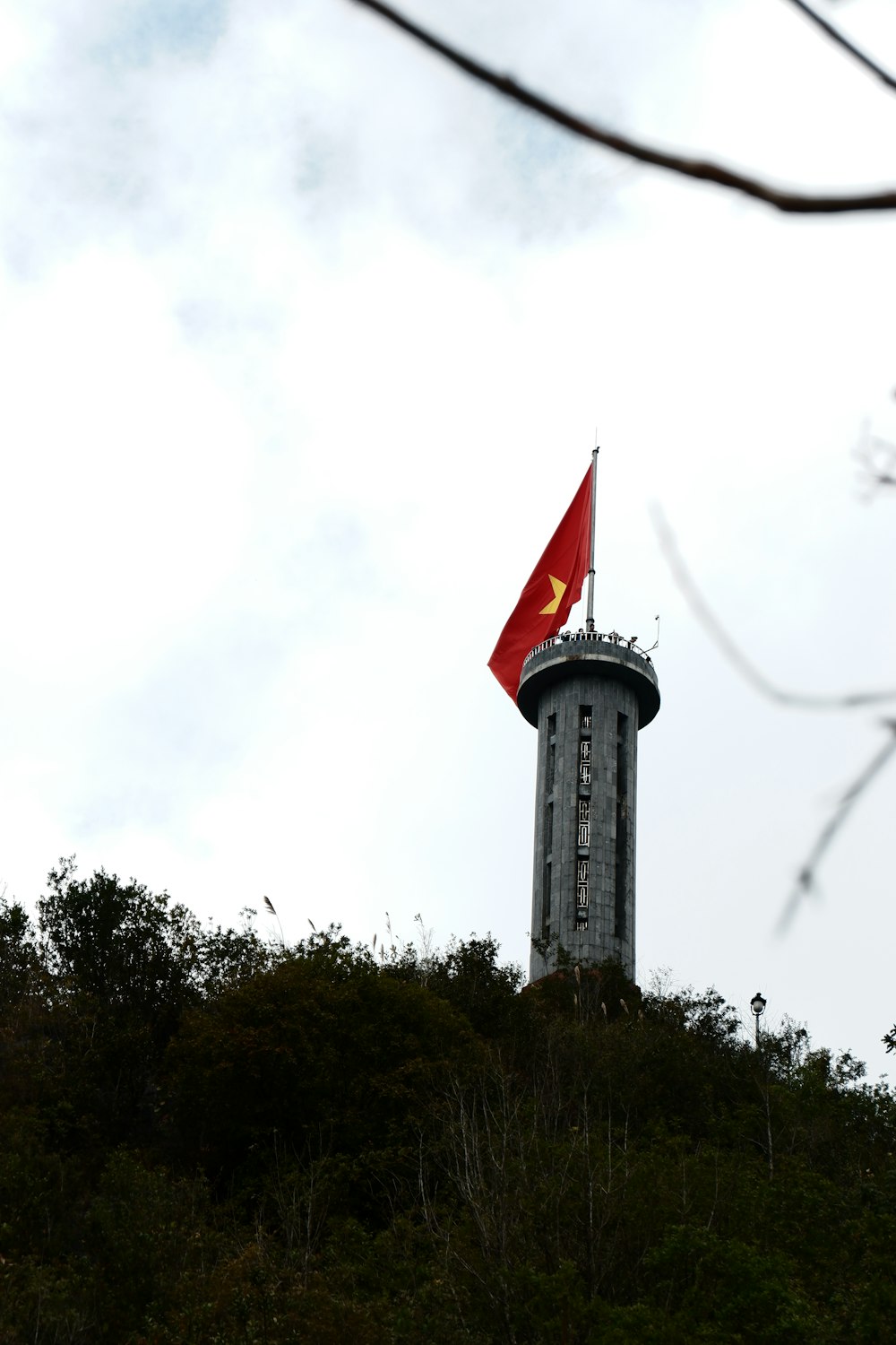 a flag on top of a tower on a hill