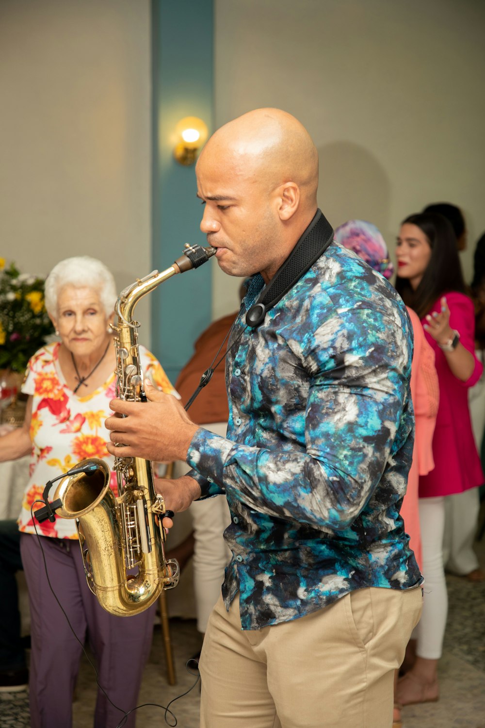 a man playing a saxophone in front of a group of people