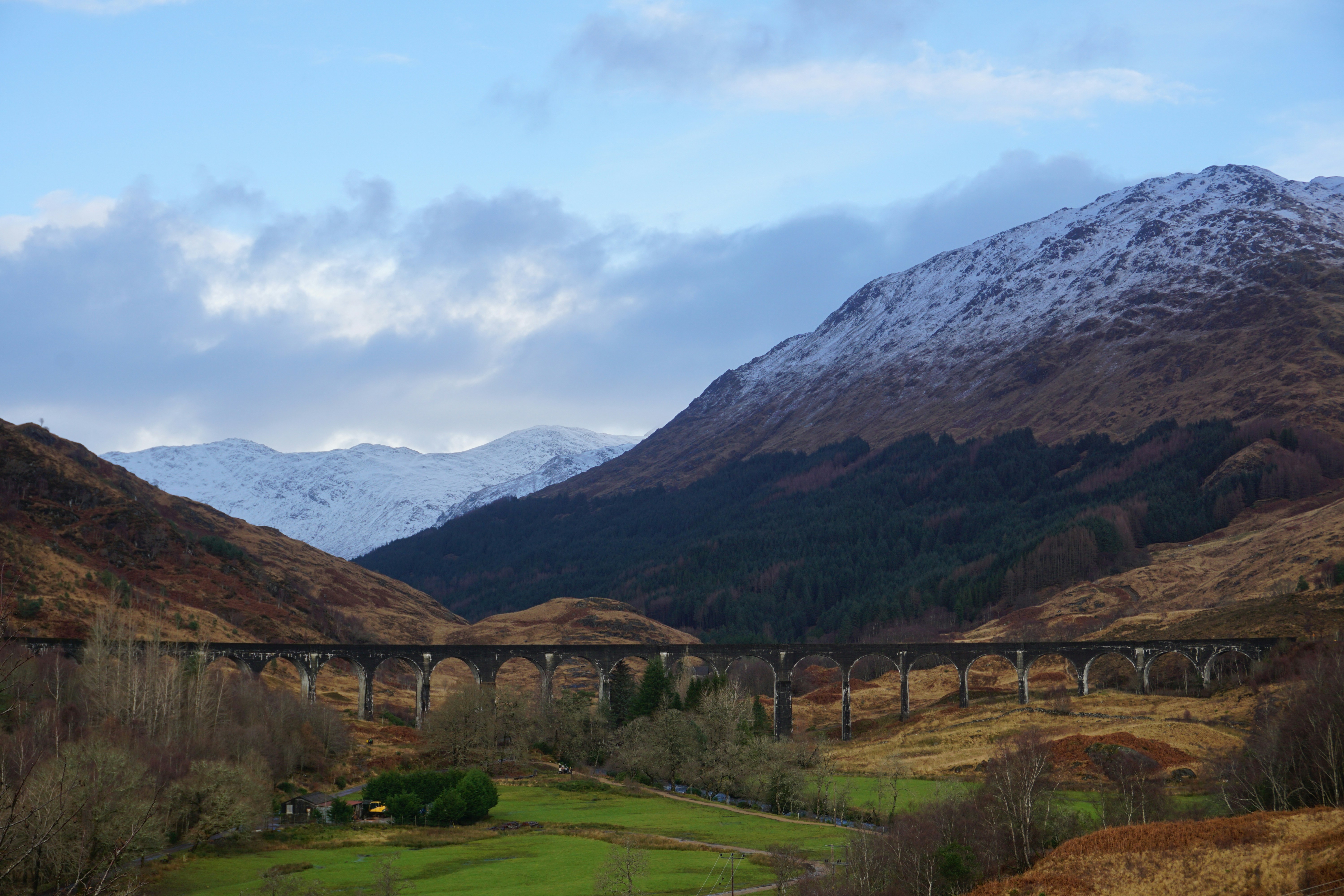 a train traveling over a bridge in the mountains
