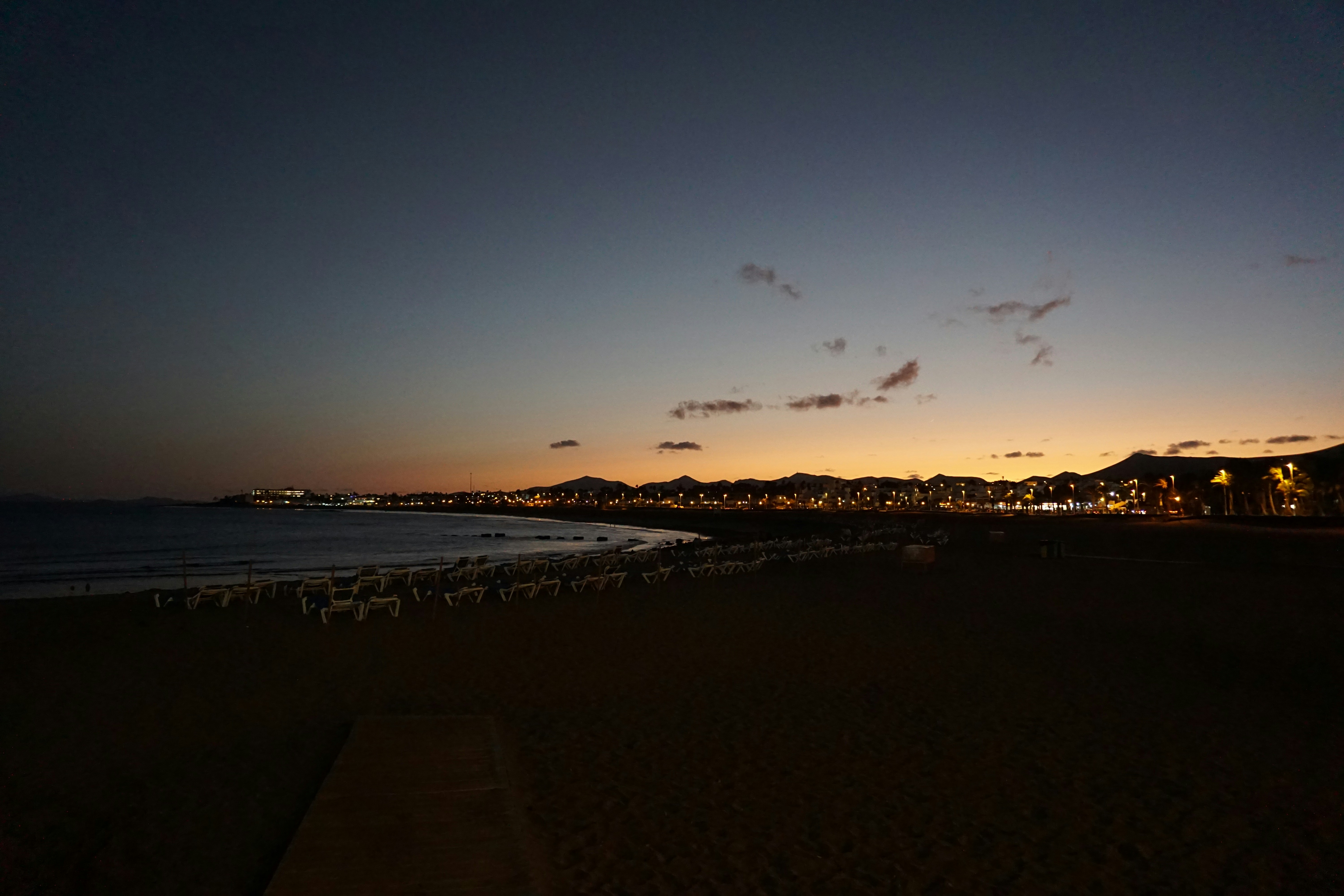 a view of a beach at night with the lights on