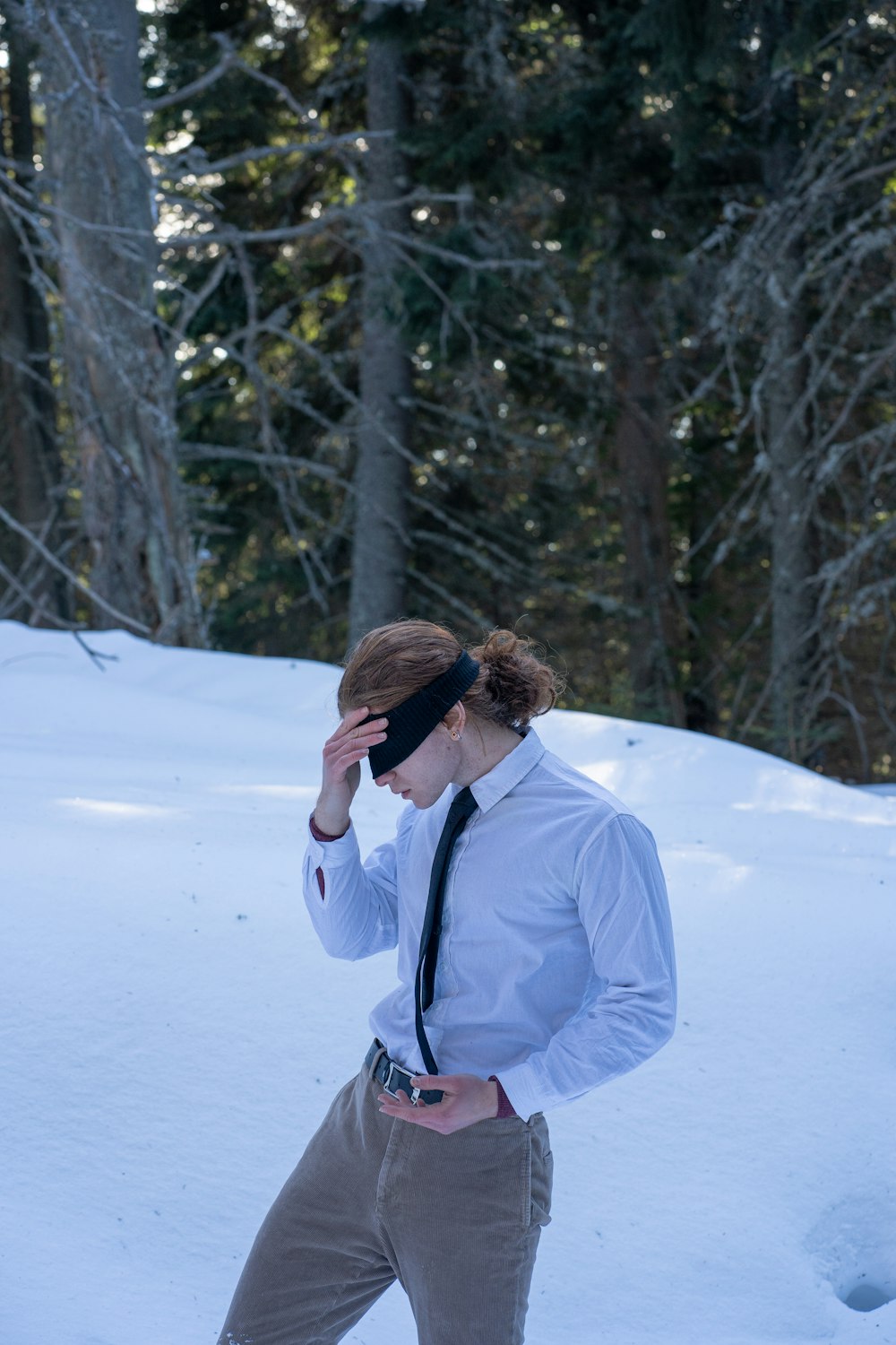 a man in a tie is walking in the snow