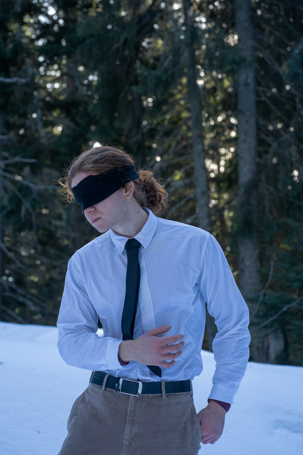 a man wearing a blindfold standing in the snow
