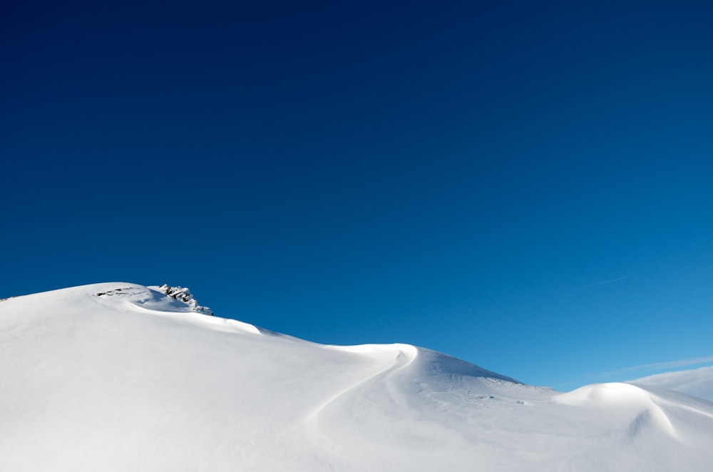 a person riding a snowboard down a snow covered slope