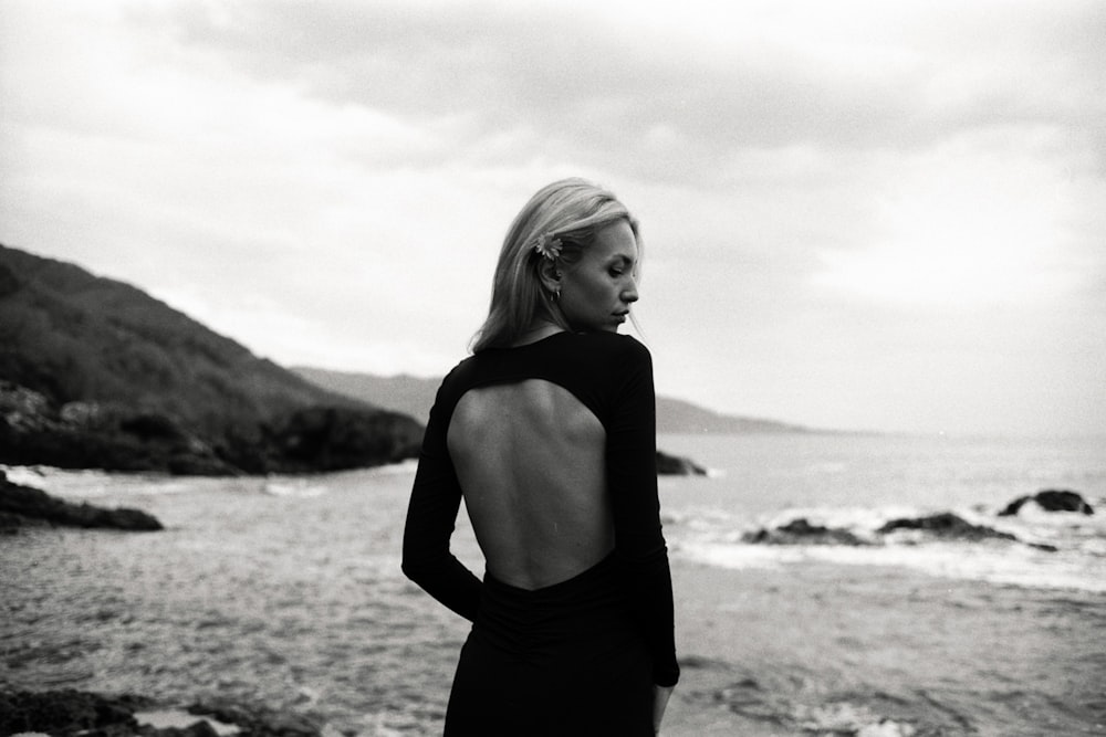 a woman standing on a beach next to the ocean