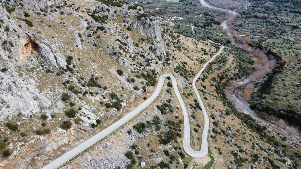 an aerial view of a winding road in the mountains