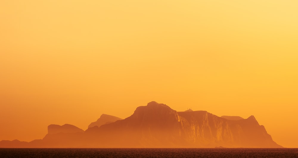 a large mountain in the middle of a body of water