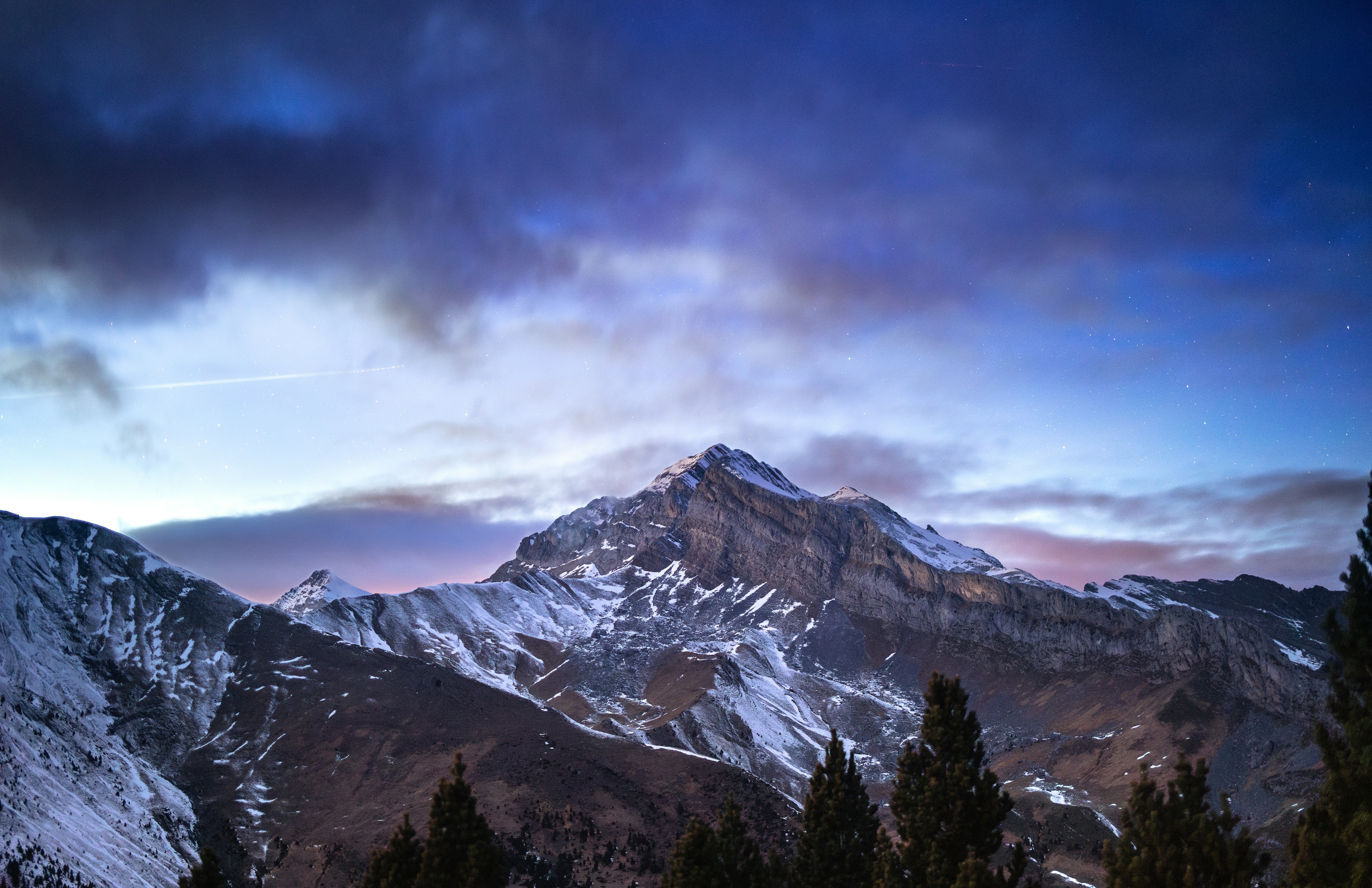 A snow covered mountain under a cloudy sky photo – Free Blue Image on ...