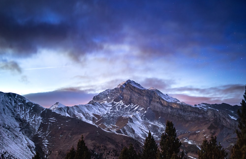 a snow covered mountain under a cloudy sky