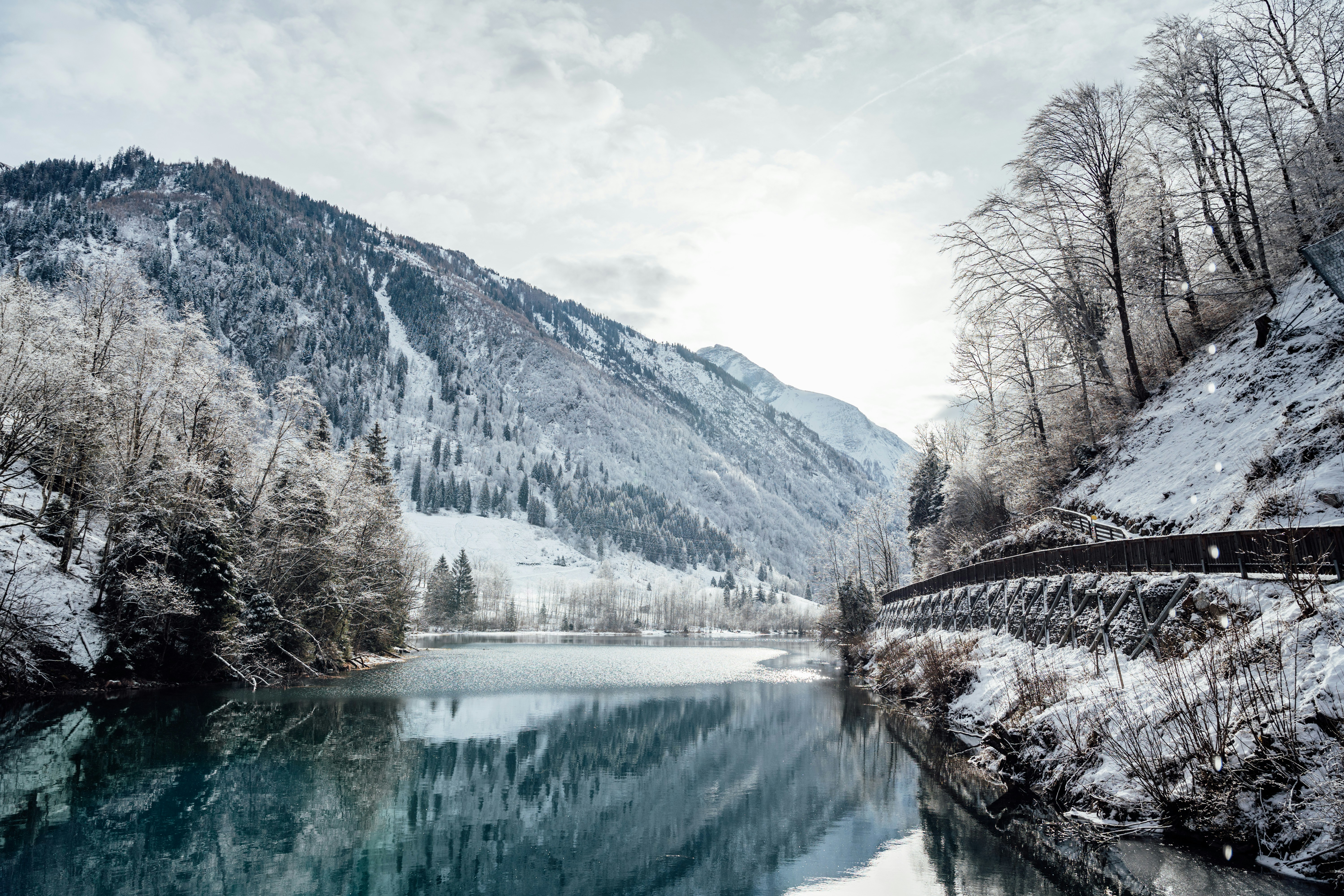 a river surrounded by snow covered mountains and trees
