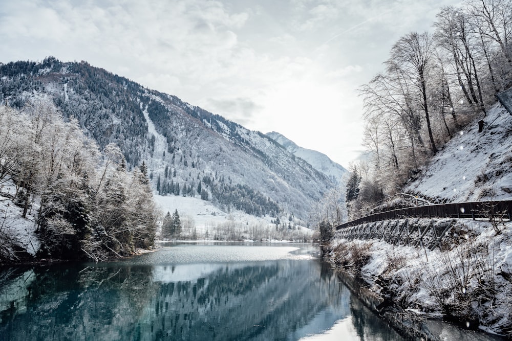 a river surrounded by snow covered mountains and trees