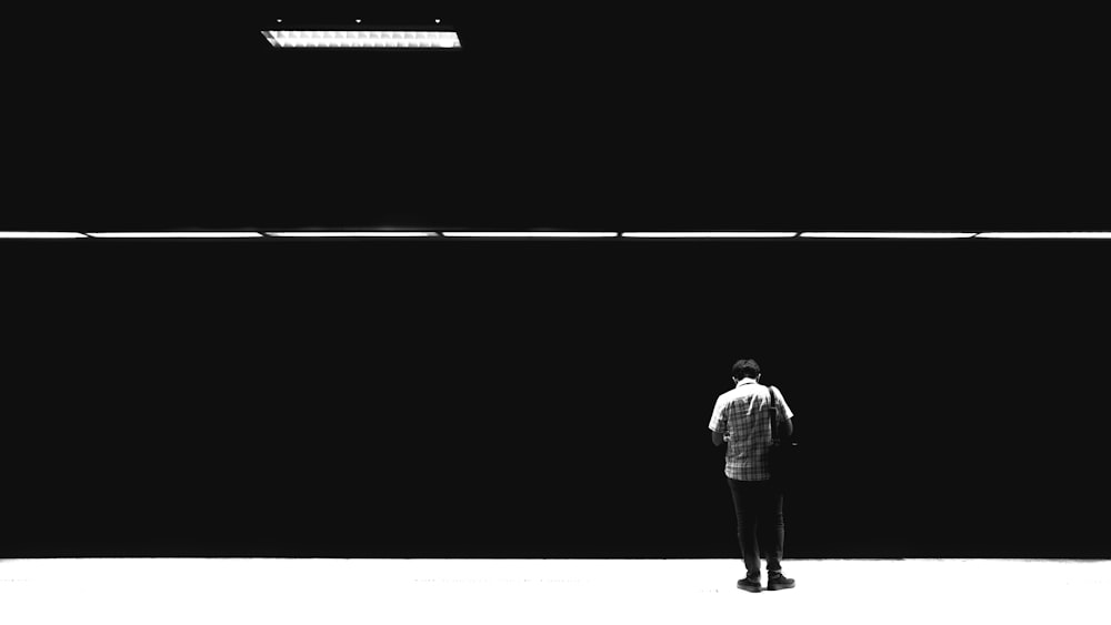 a person standing in front of a black wall