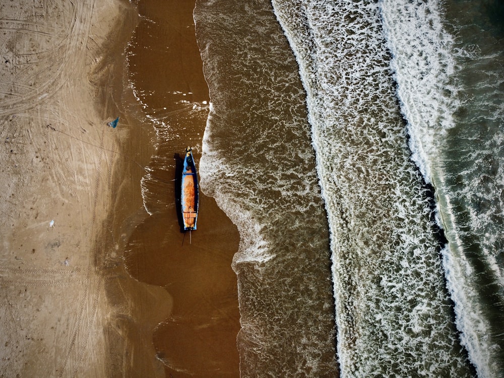 an aerial view of a boat on the beach
