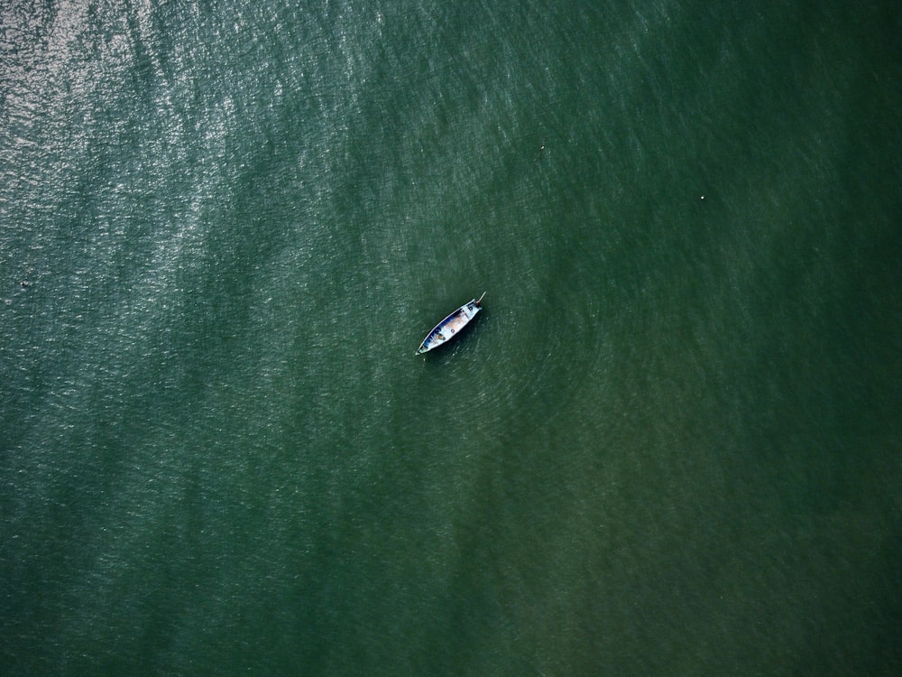 a small boat floating on top of a large body of water