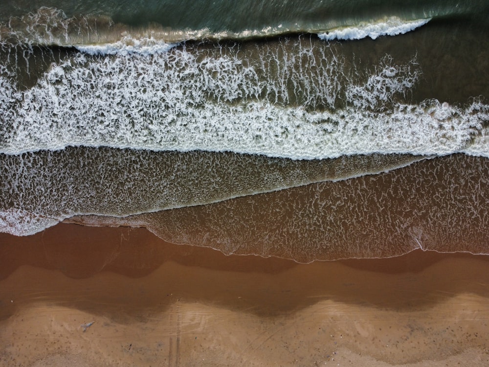 an aerial view of a beach with waves and sand