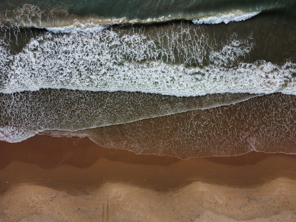 Una veduta aerea di una spiaggia con onde e sabbia