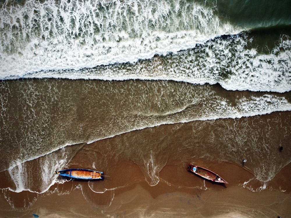 Dos barcos sentados en lo alto de una playa junto al océano