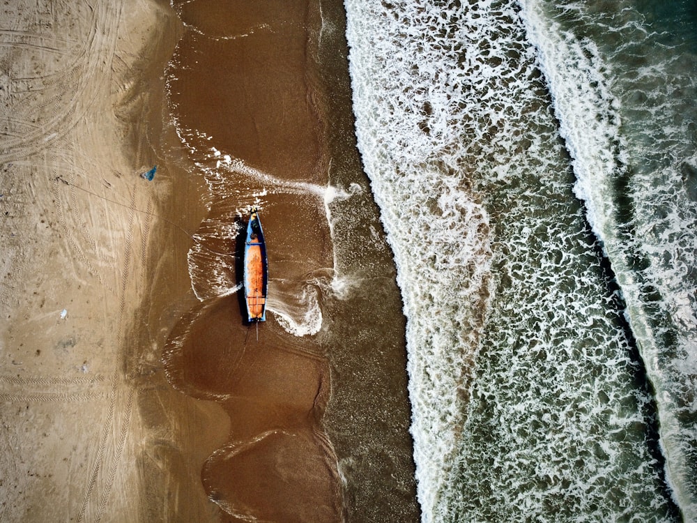 an aerial view of a boat on the beach