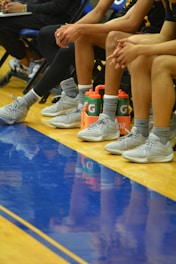 a group of people sitting on top of a basketball court