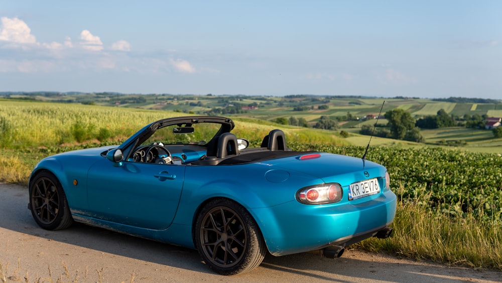 a blue sports car parked on the side of the road