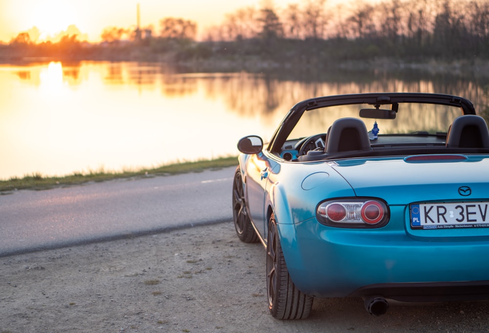 a blue sports car parked on the side of the road