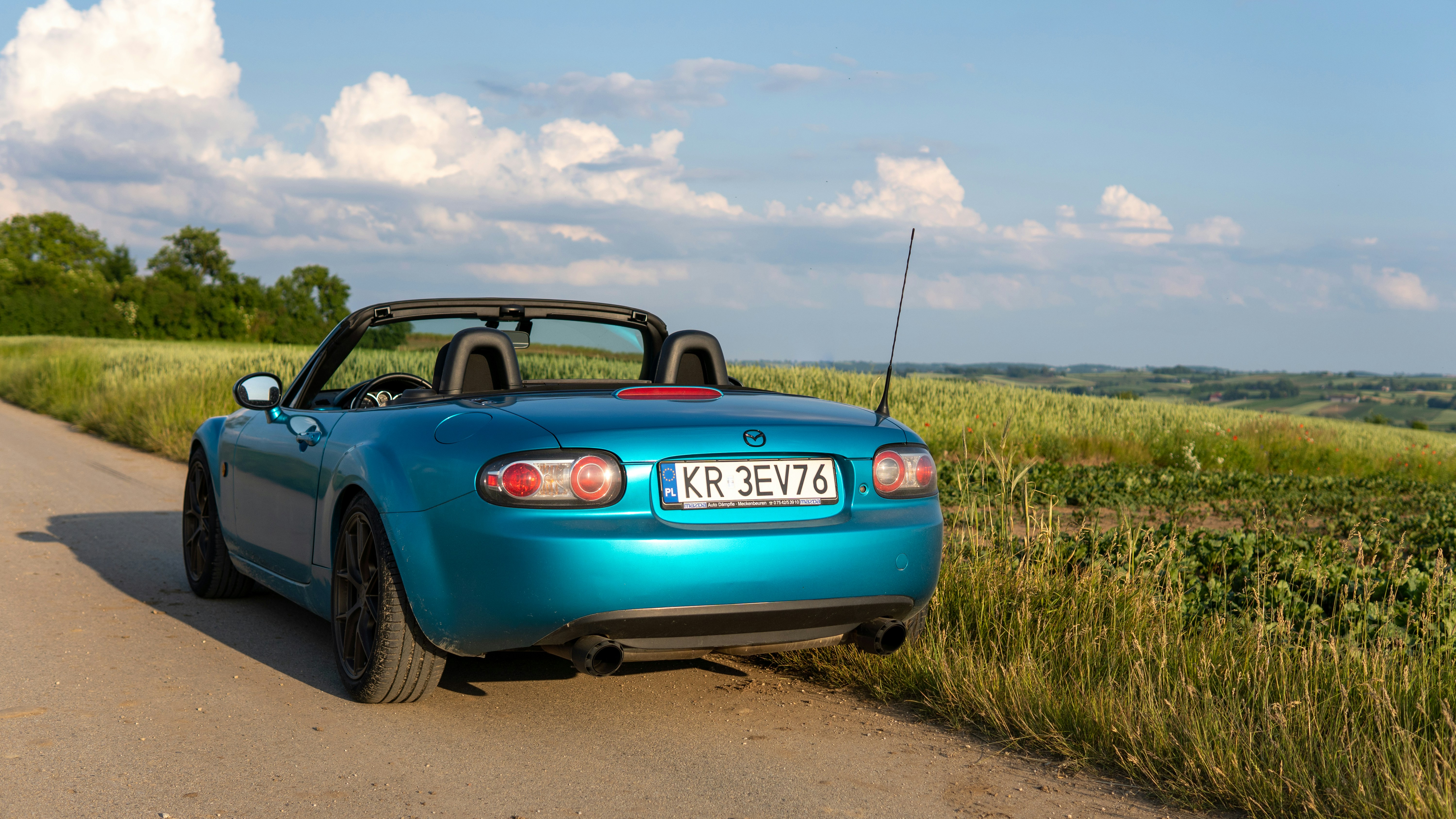 a blue sports car parked on the side of the road