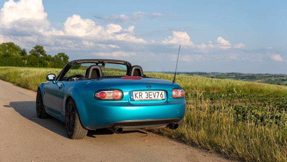 a blue sports car parked on the side of the road