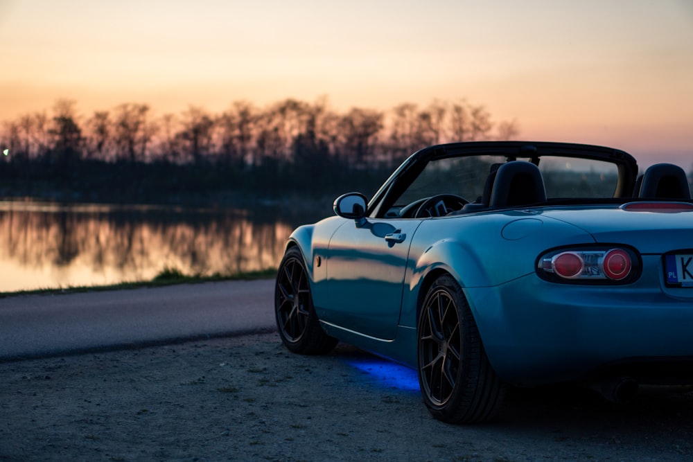 a blue sports car parked on the side of the road