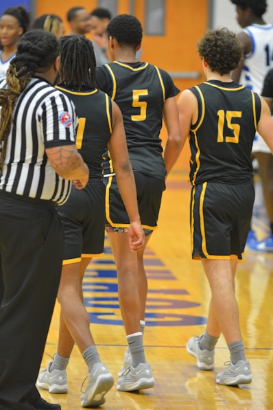 a group of young men standing on top of a basketball court