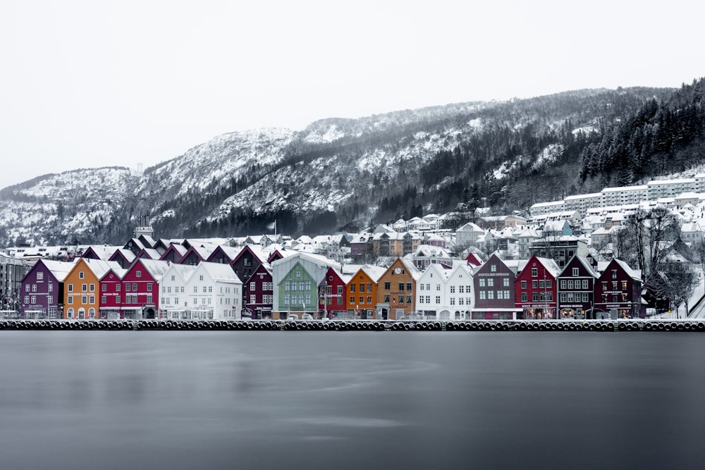 a row of houses sitting on top of a snow covered hillside