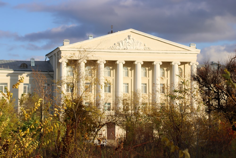 a white building with columns and a cross on top of it