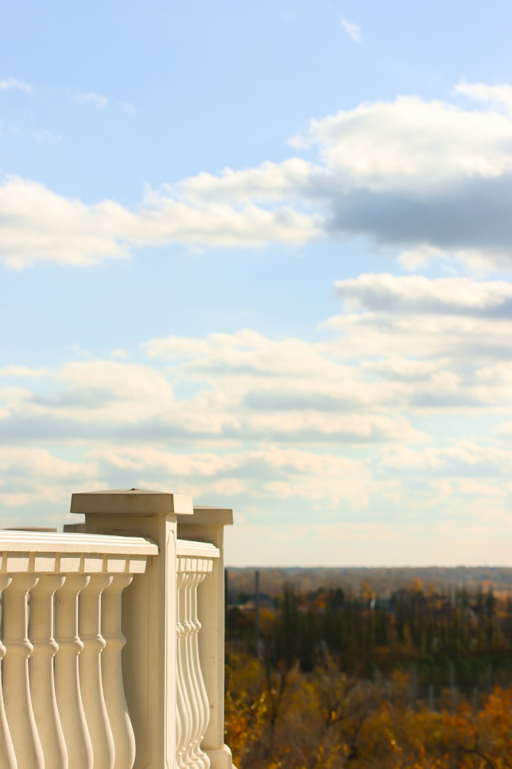 a balcony with a white railing and a view of trees