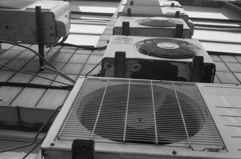 a row of air conditioners sitting on top of a tiled floor