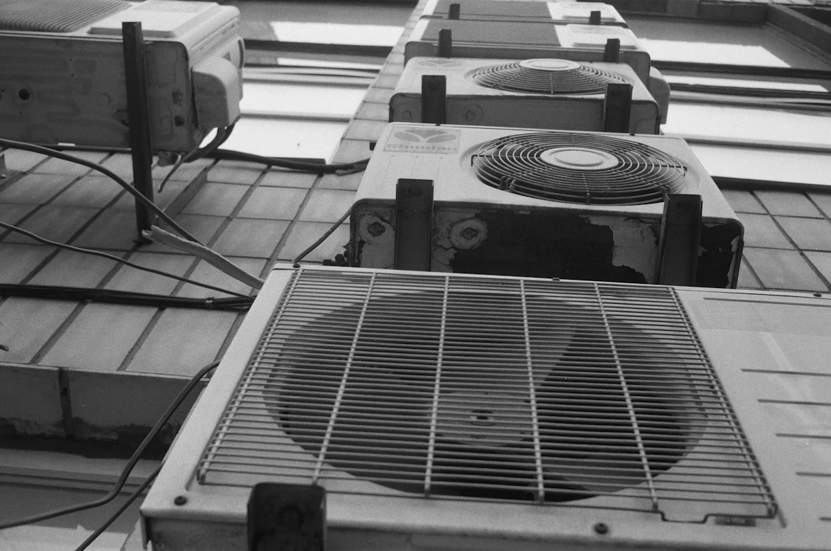 Row of outdoor condenser units on a tiled floor
