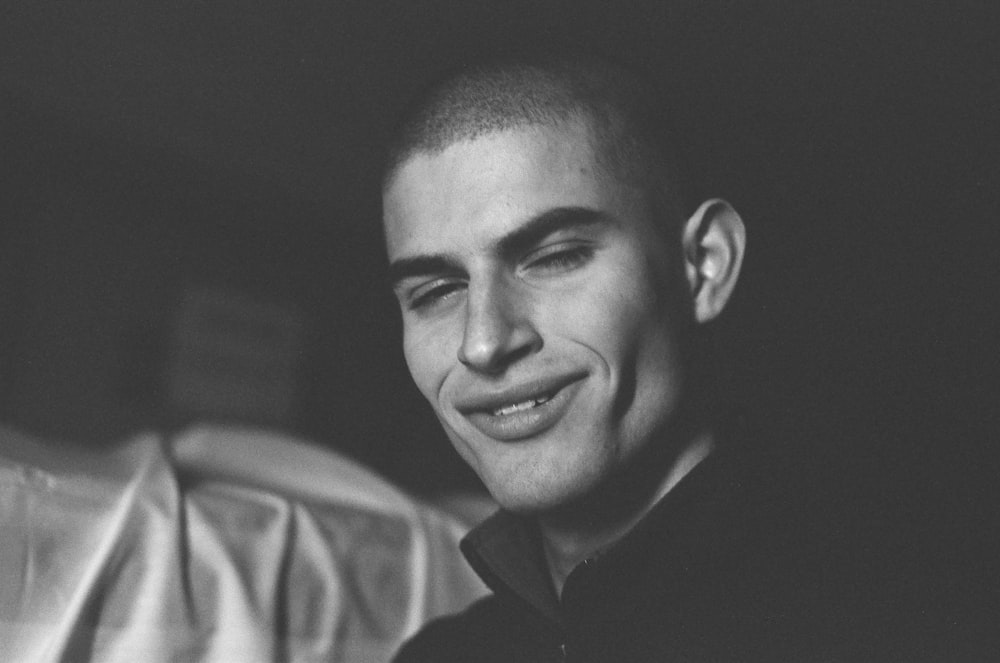 a black and white photo of a man smiling