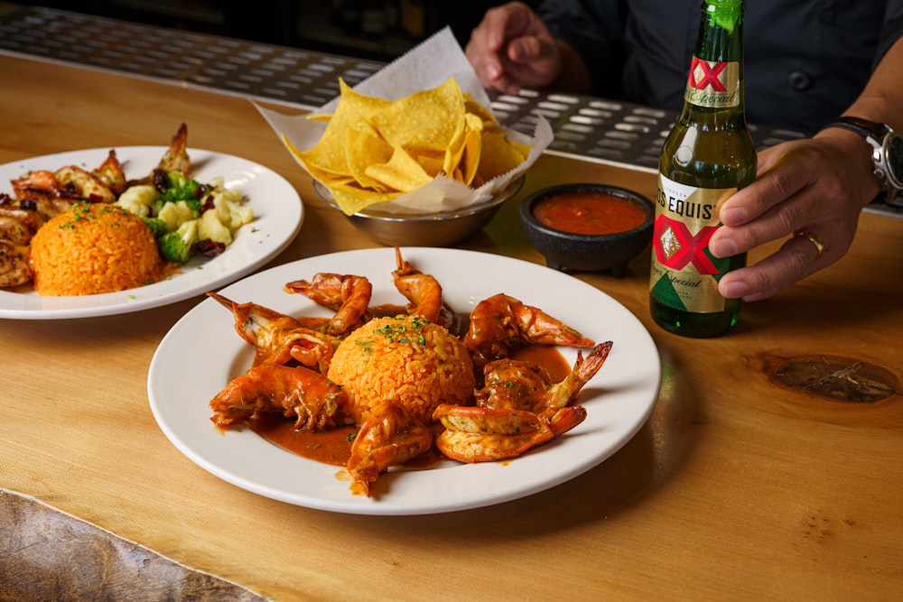 a person sitting at a table with two plates of food