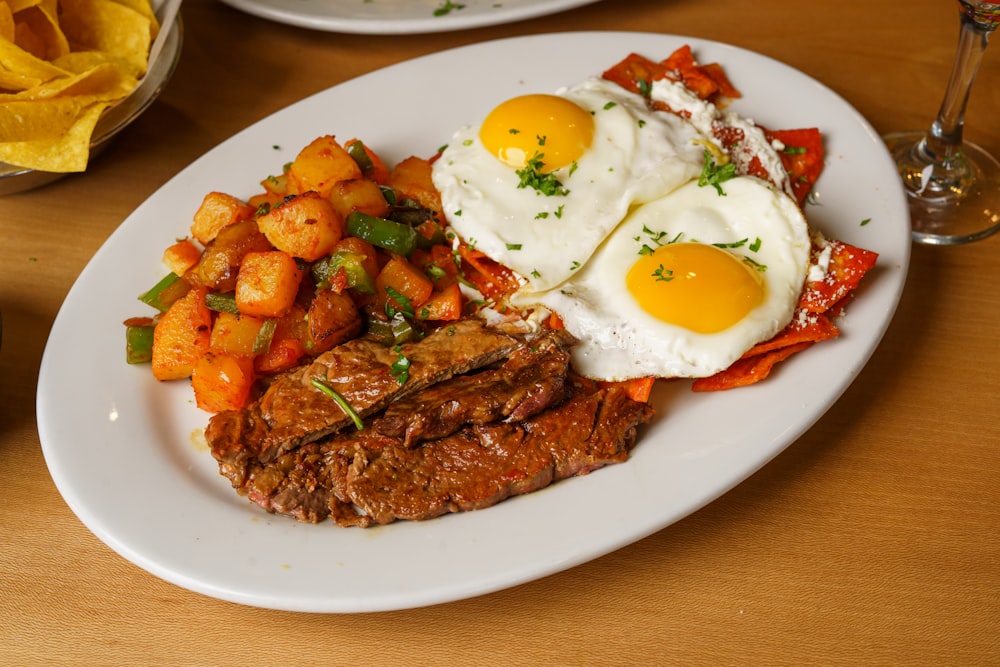 a white plate topped with meat and eggs