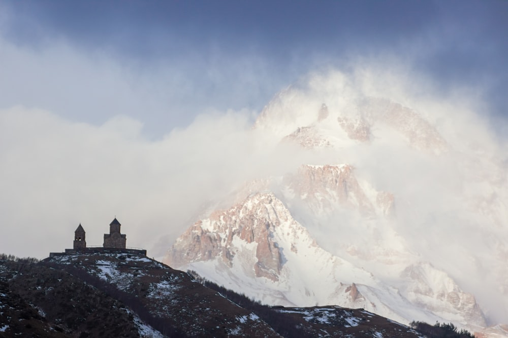 a snow covered mountain with a church on top