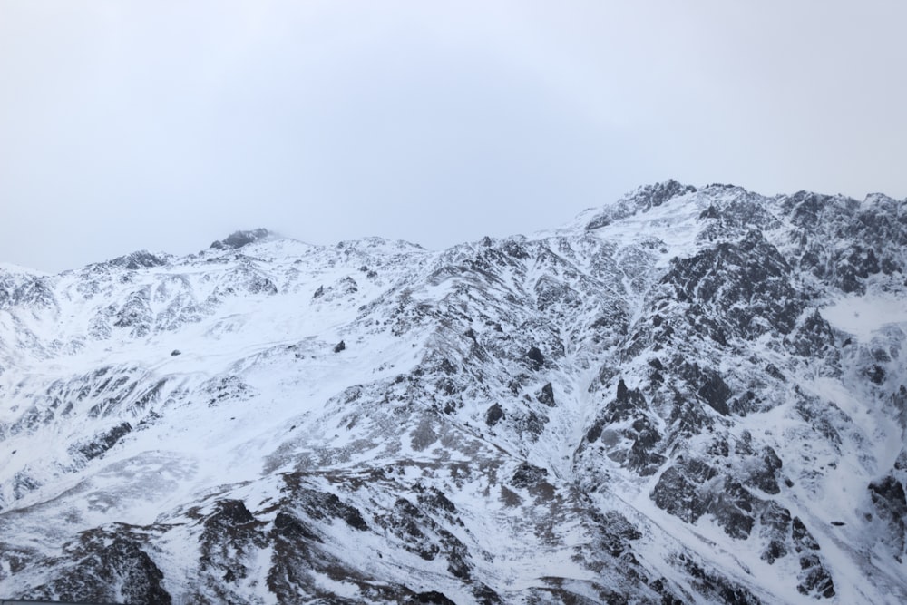 a mountain covered in snow with a sky background