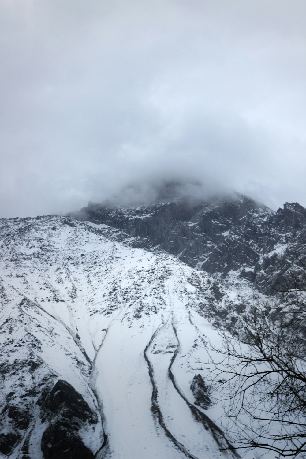 a snow covered mountain with a trail going through it