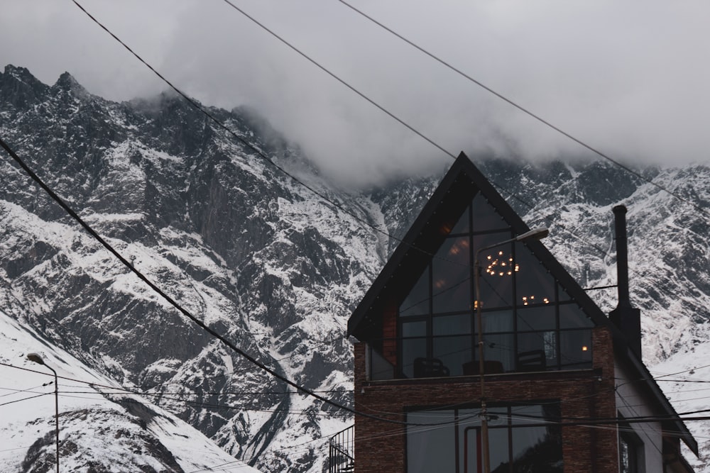 a snow covered mountain with a house in the foreground