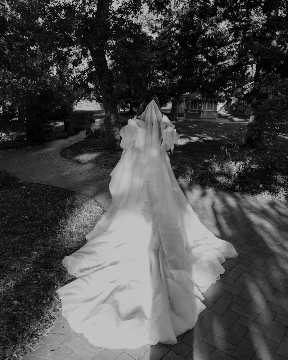 a woman in a wedding dress walking down a path