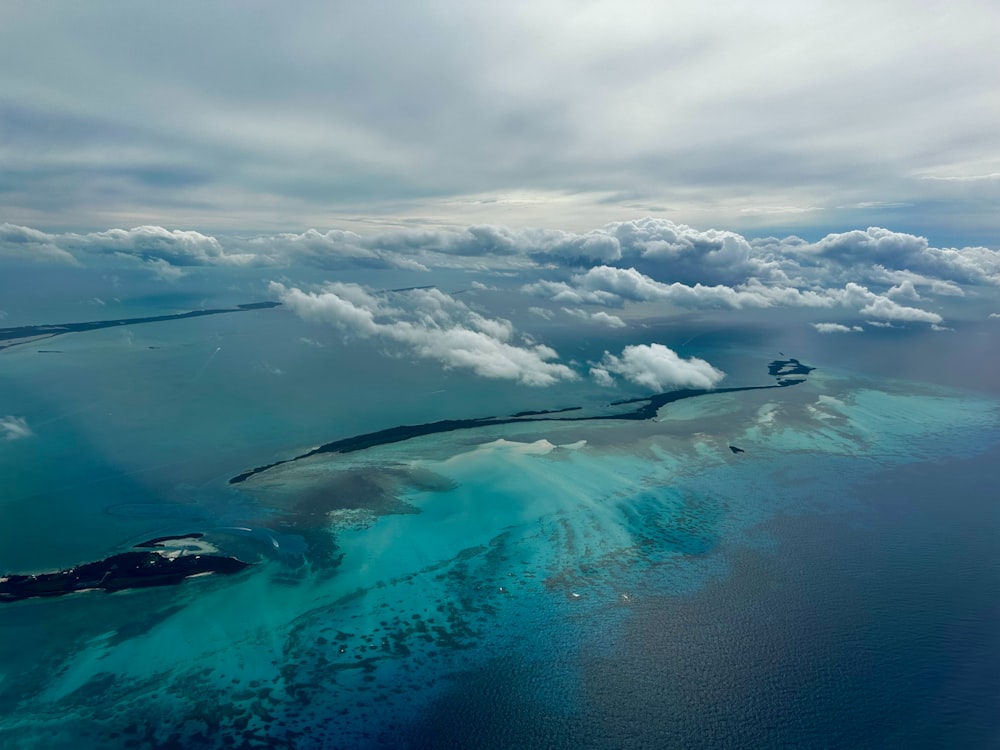 an aerial view of a body of water surrounded by clouds