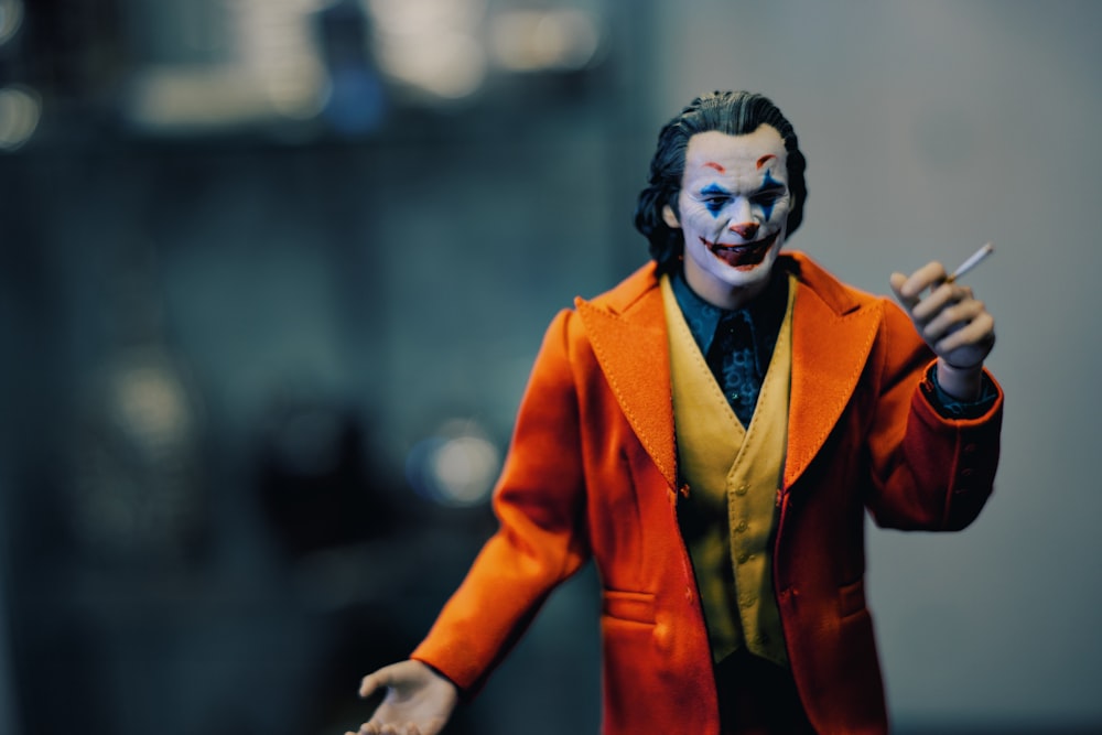 a close up of a toy joker with a cigarette